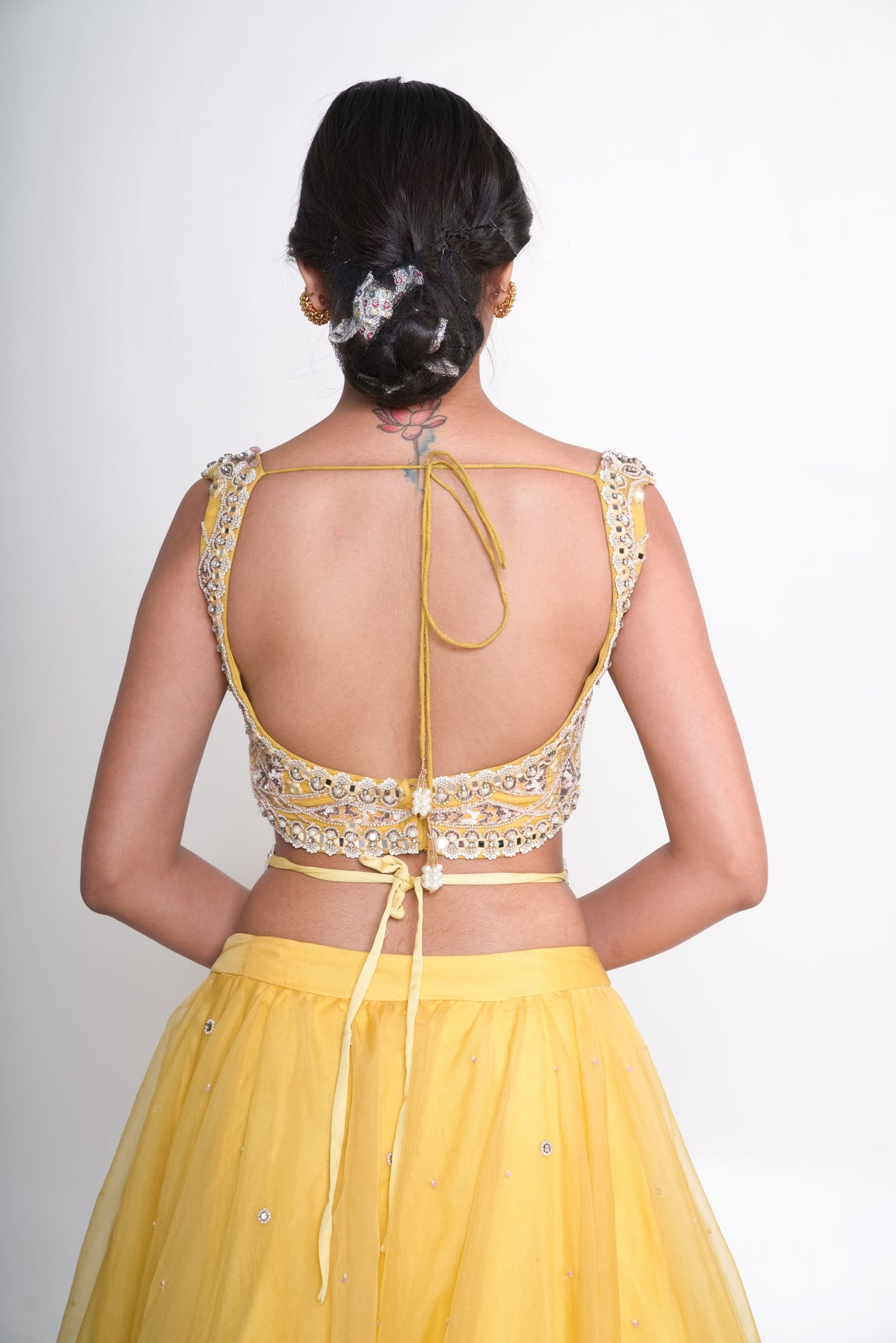 Spaghetti blouse with yellow layered lehenga and net shrug
