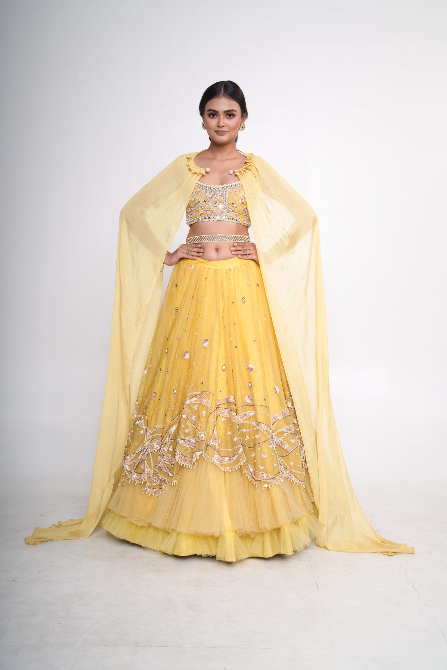 Spaghetti blouse with yellow layered lehenga and net shrug