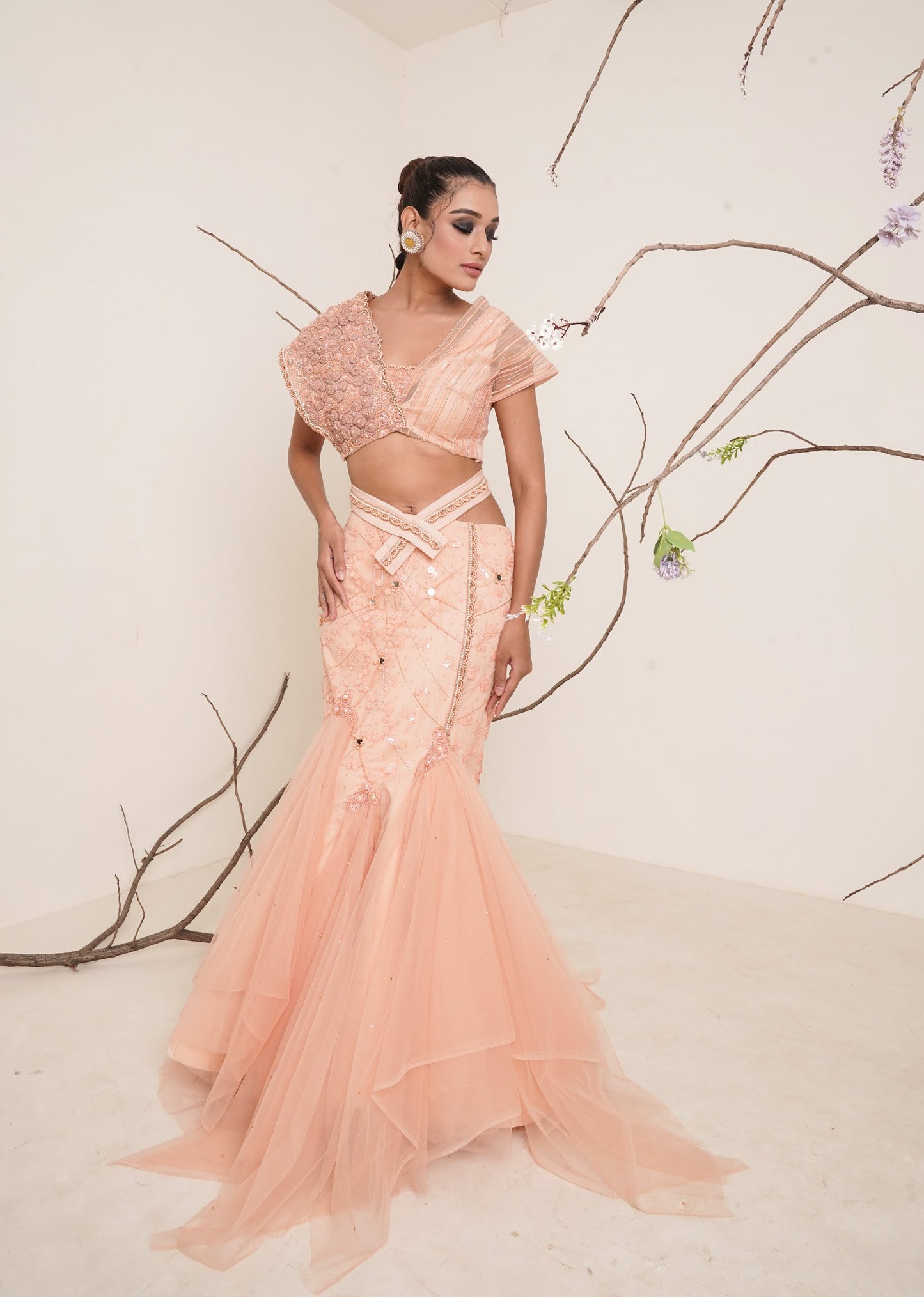 Peach fish cut lehenga with asymmetrical blouse look.