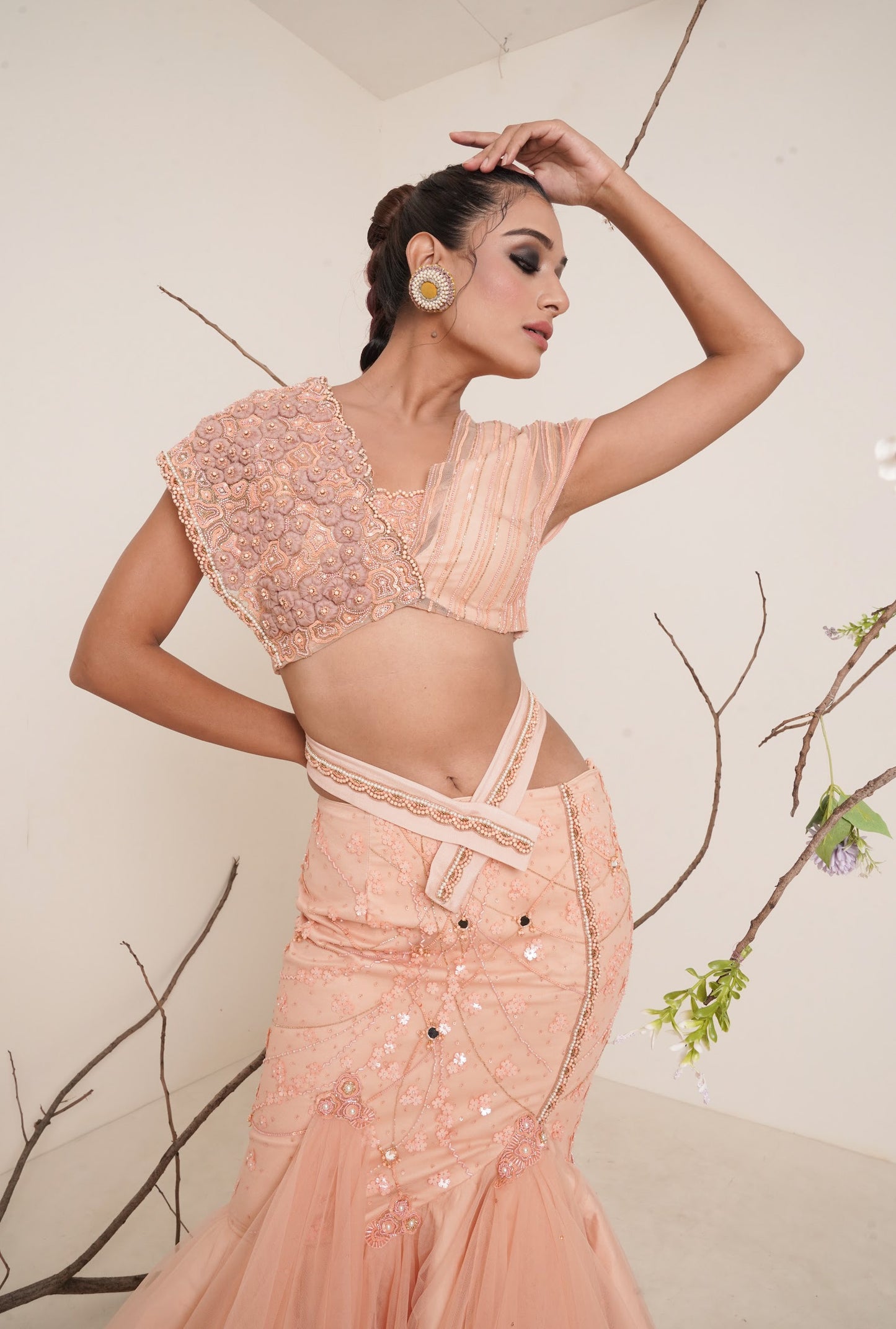 Peach fish cut lehenga with asymmetrical blouse look.