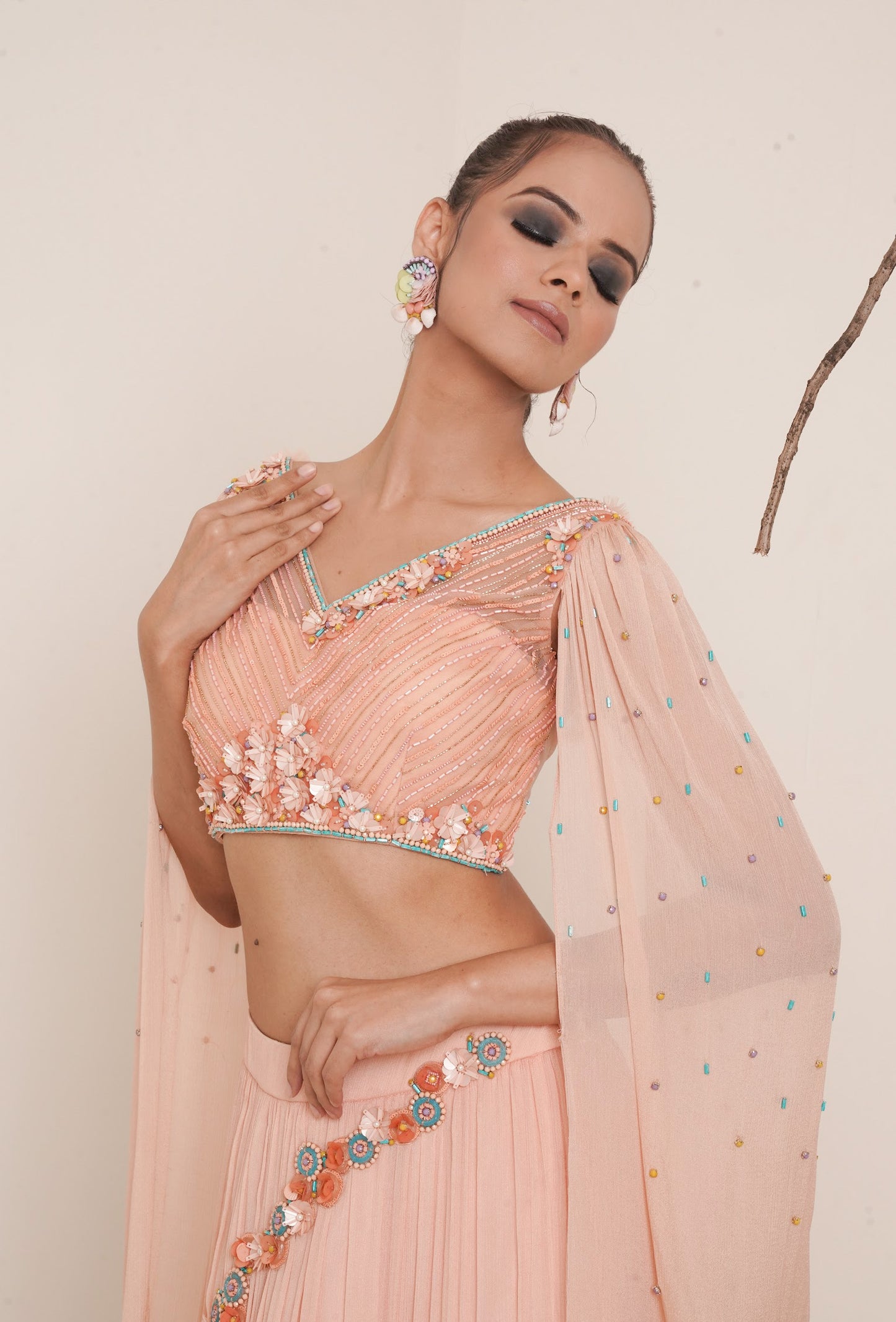 Flared peach lehenga with structured shrug.