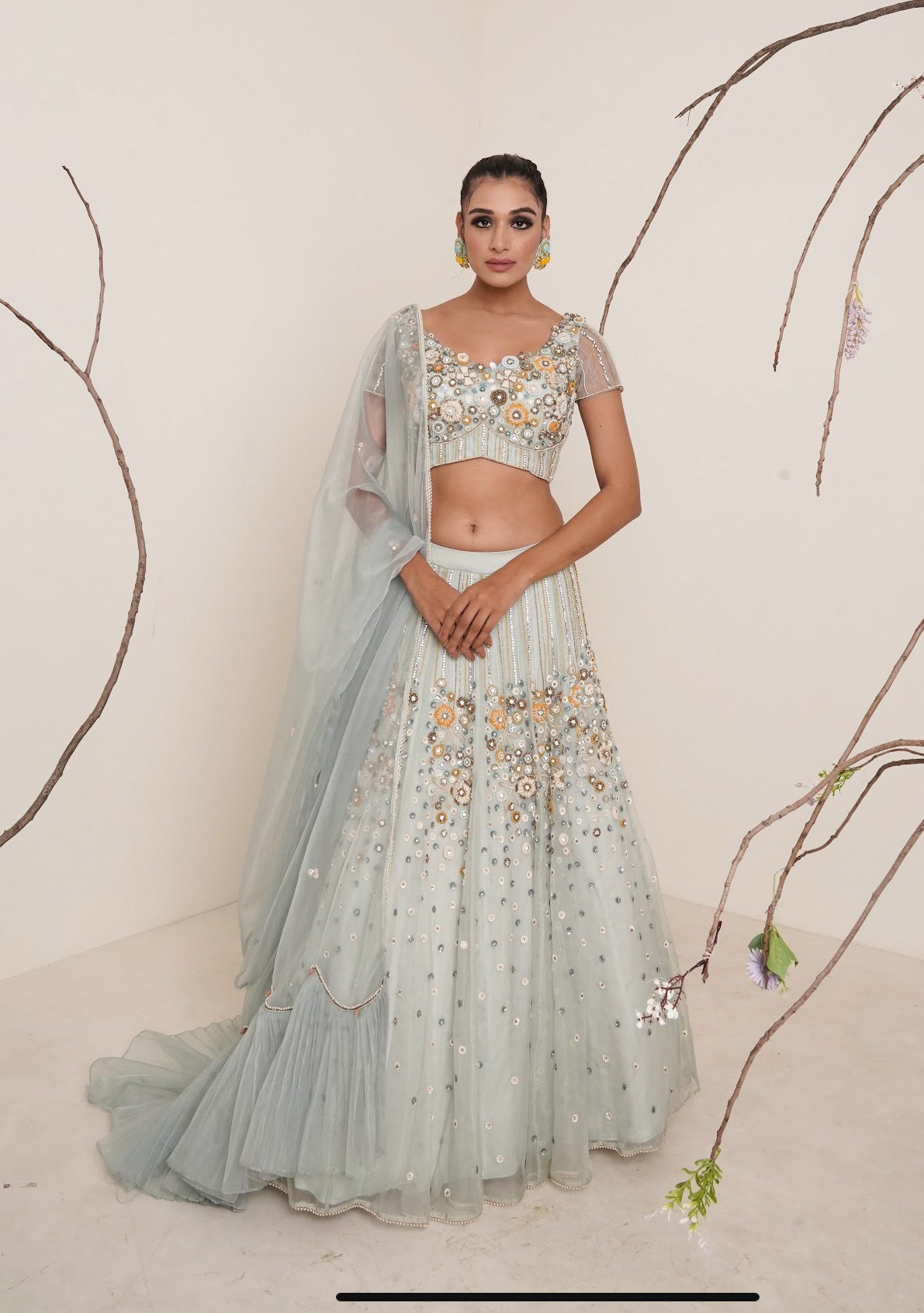 Aqua lehenga adorned in multi colour embroidery.
