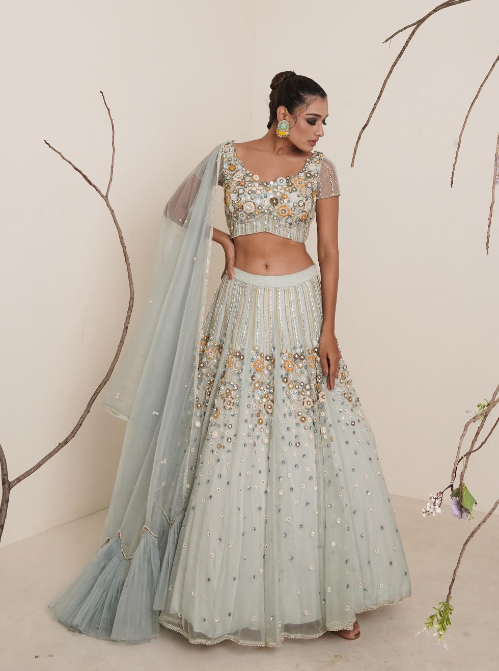 Aqua lehenga adorned in multi colour embroidery.
