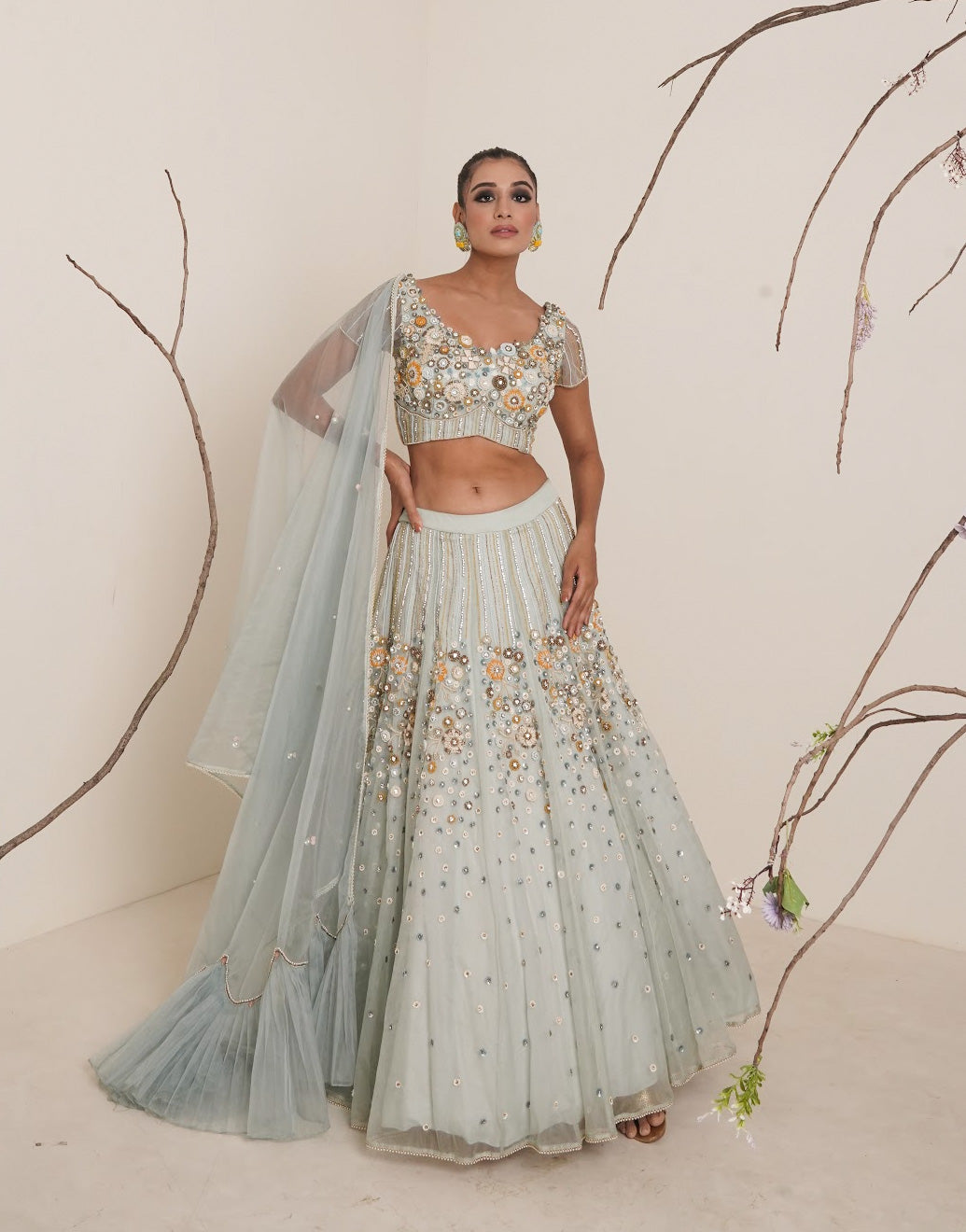 Aqua lehenga adorned in multi colour embroidery.