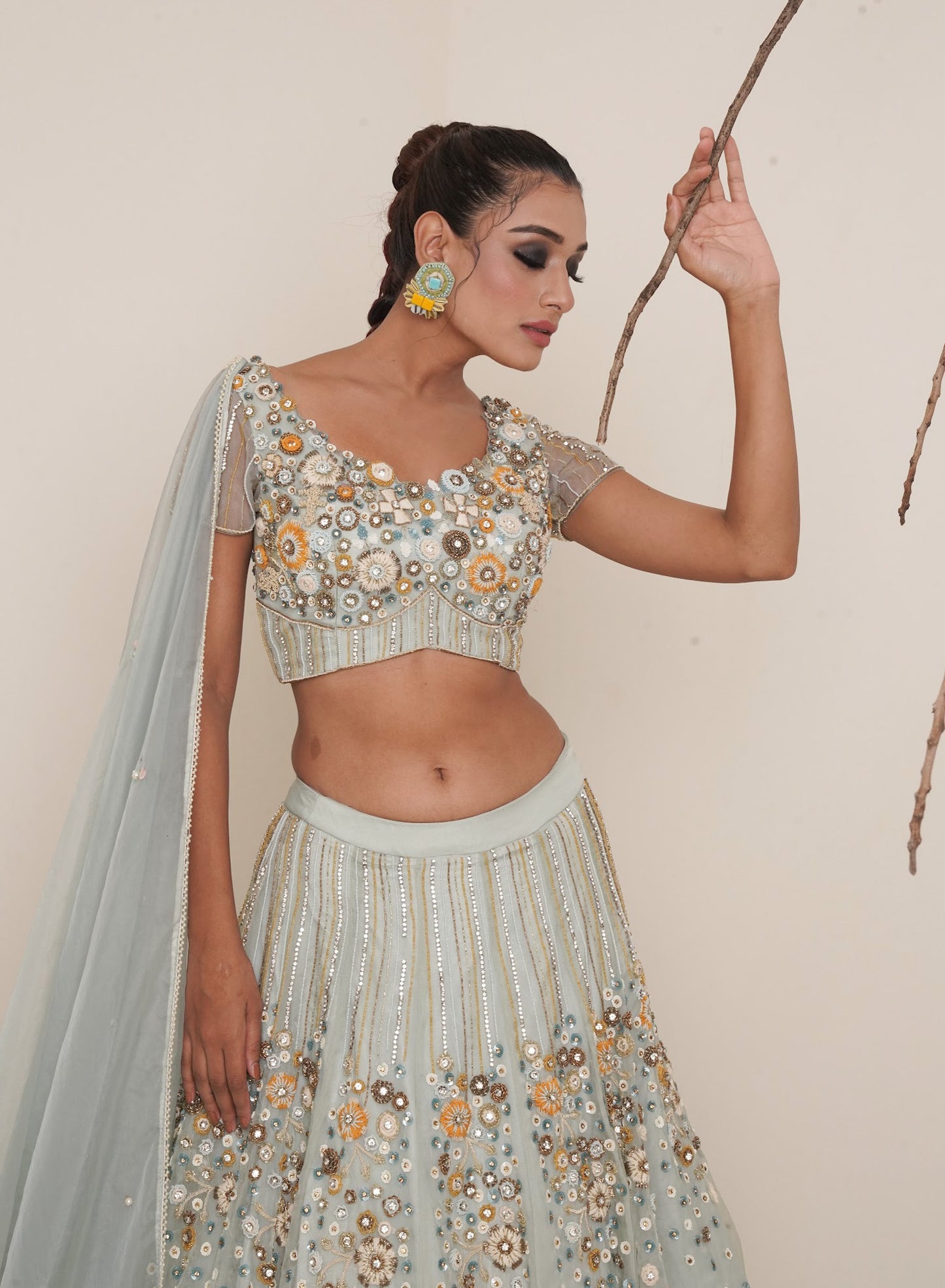 Aqua lehenga adorned in multi colour embroidery.