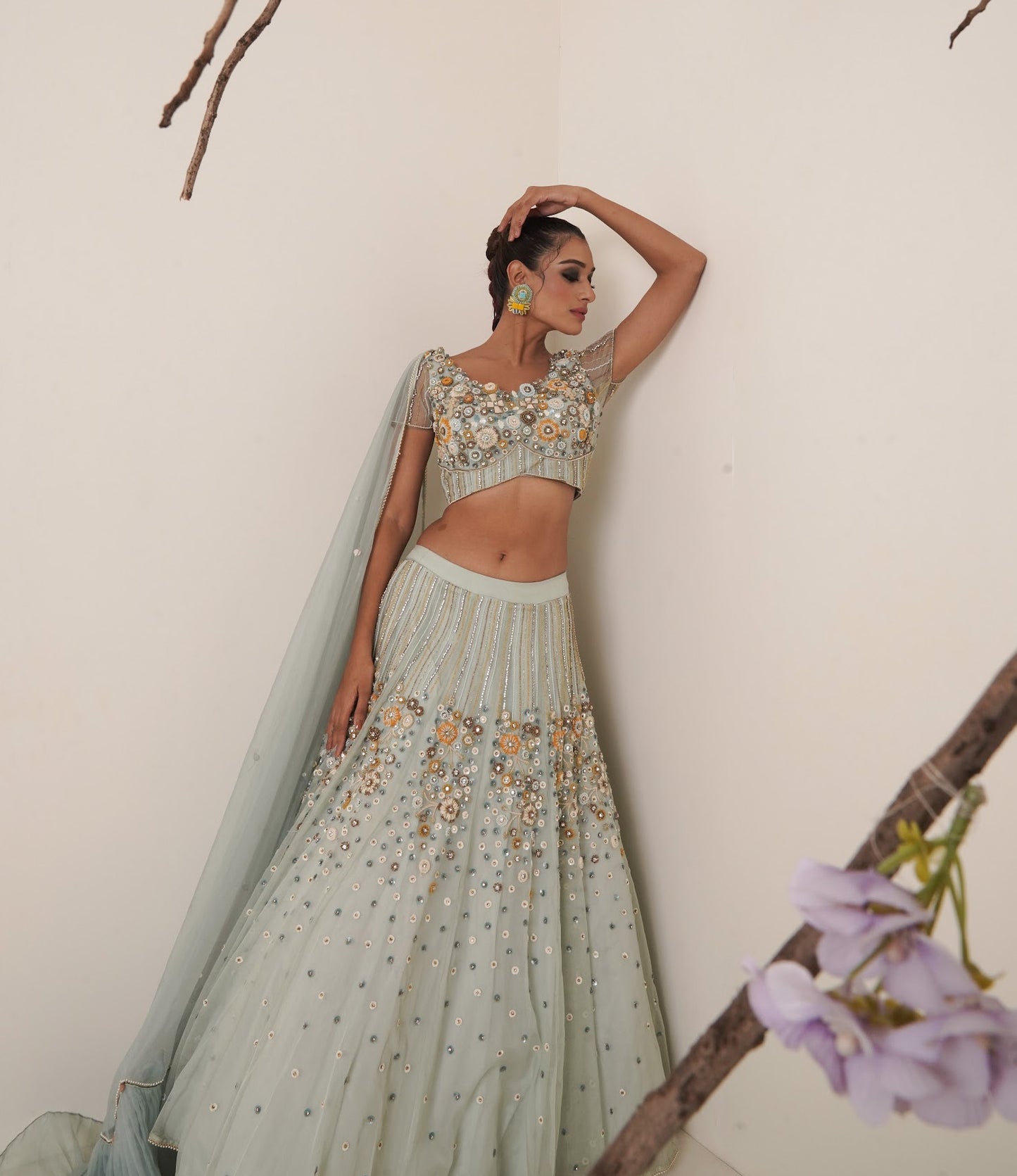 Aqua lehenga adorned in multi colour embroidery.