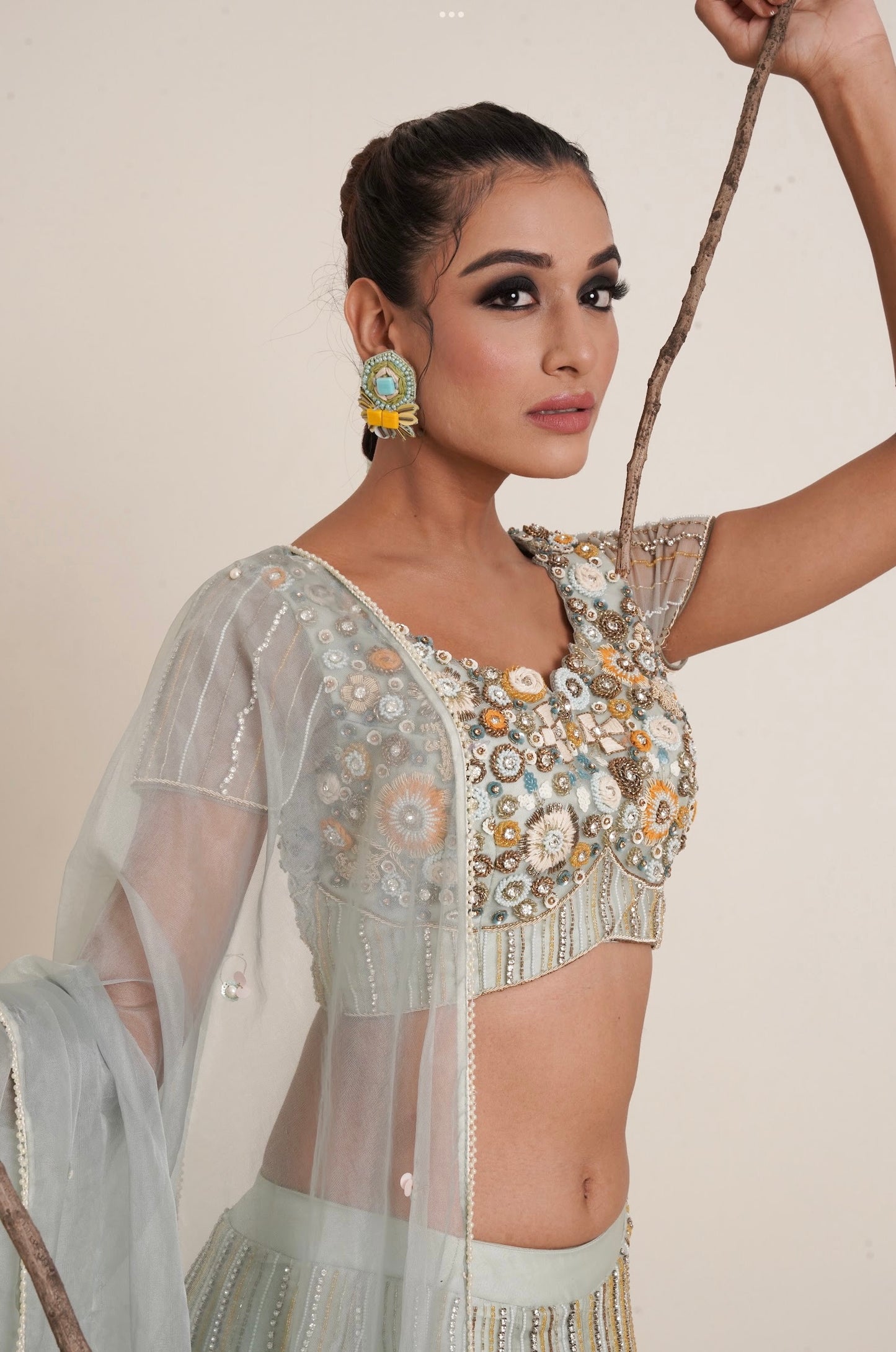 Aqua lehenga adorned in multi colour embroidery.