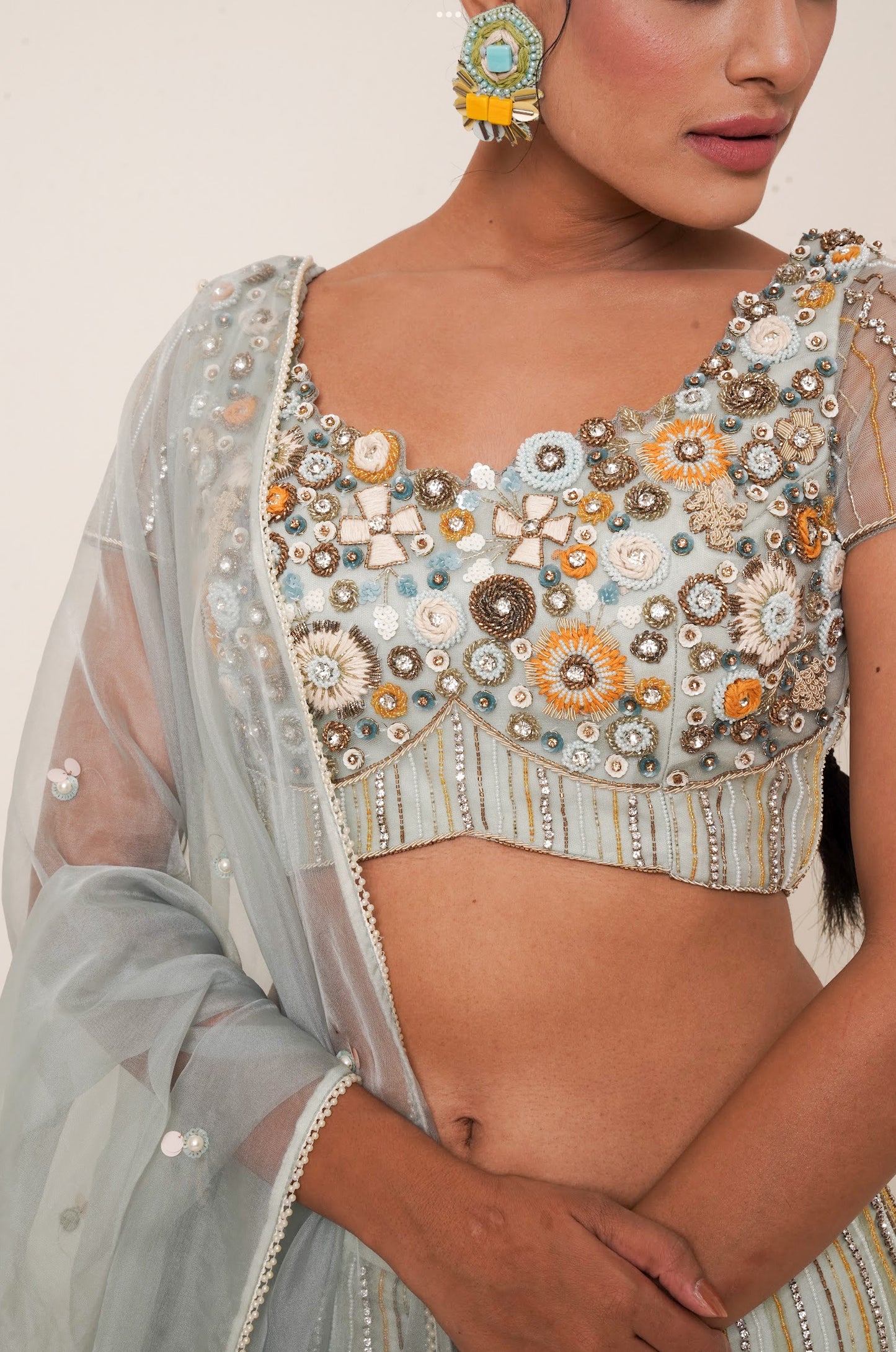 Aqua lehenga adorned in multi colour embroidery.