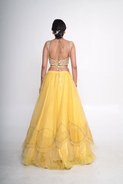 Spaghetti blouse with yellow layered lehenga and net shrug