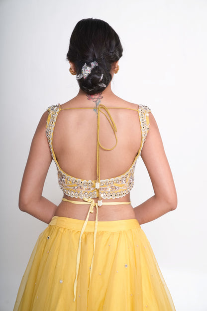 Spaghetti blouse with yellow layered lehenga and net shrug