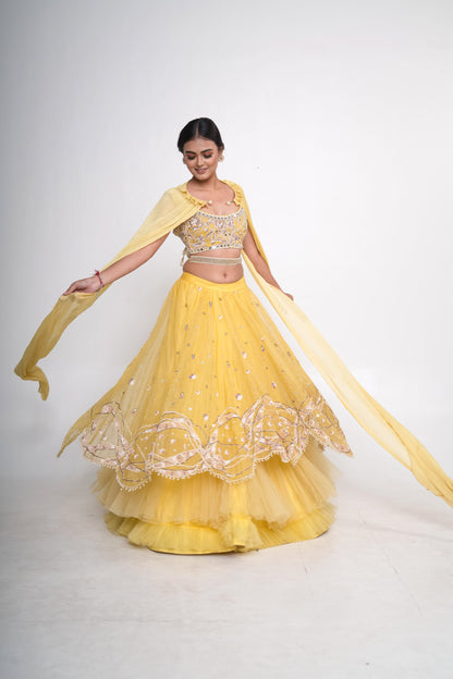 Spaghetti blouse with yellow layered lehenga and net shrug