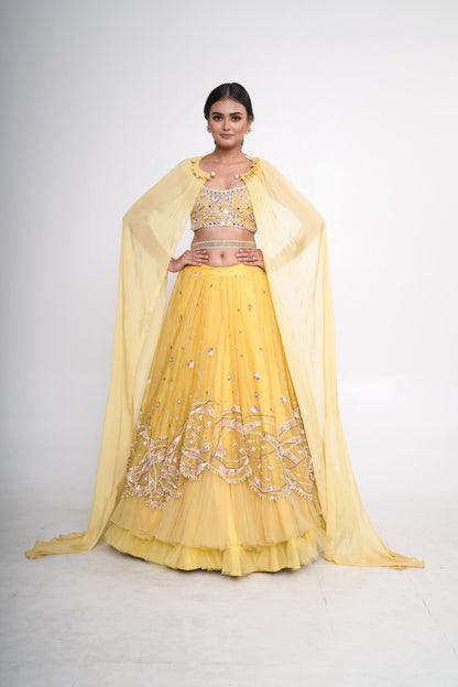 Spaghetti blouse with yellow layered lehenga and net shrug
