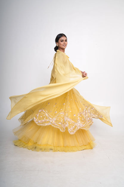 Spaghetti blouse with yellow layered lehenga and net shrug