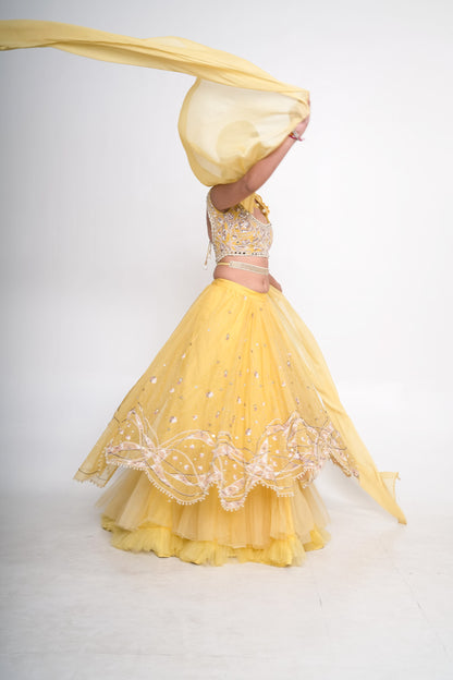 Spaghetti blouse with yellow layered lehenga and net shrug