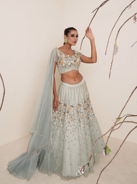Aqua lehenga adorned in multi colour embroidery.